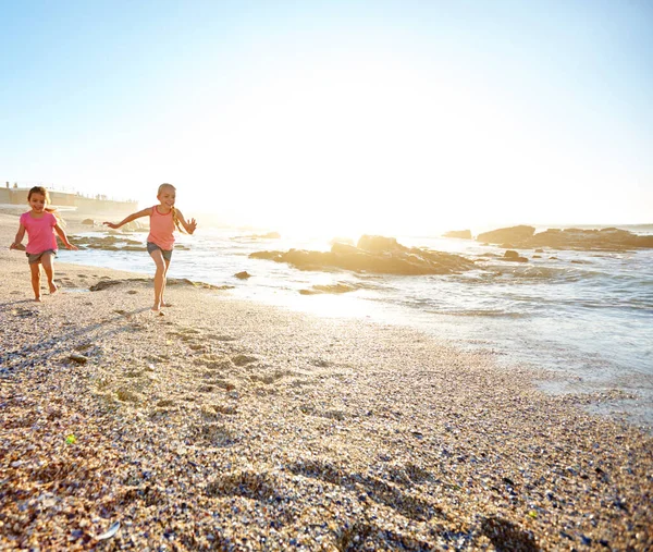 stock image The beach is their happy place. two little girls having fun on the beach