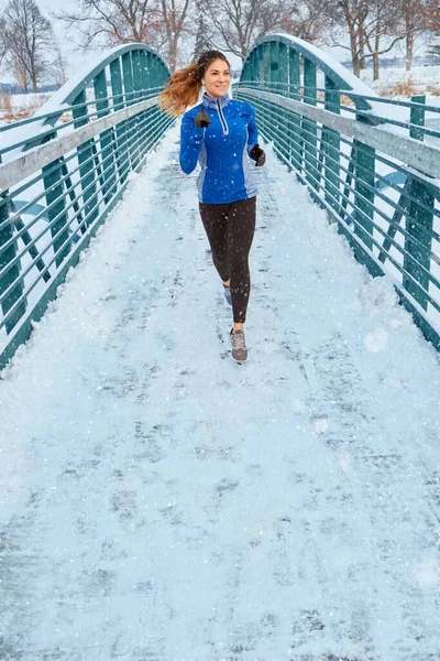 私たちは一年を通して同じケアを体に示さなければなりません 雪の中を走りながら暖かい服を着た女性が — ストック写真