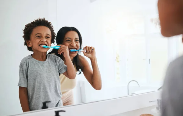 Learning, mother and son brushing teeth, dental hygiene and wellness at home, bathroom and bonding. Family, female parent or mama with male child, kid or boy with oral health, cleaning mouth or smile.