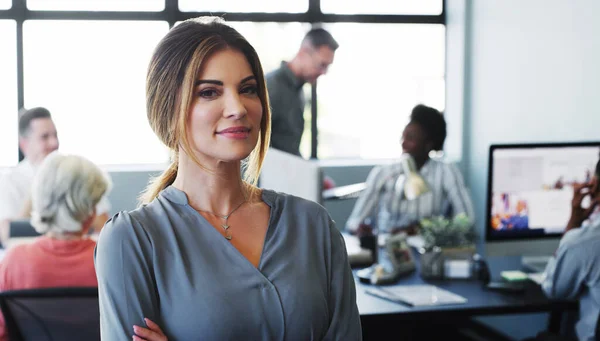 stock image Great managers keep their teams focused on the company mission. Portrait of a confident young businesswoman working in a modern office with her colleagues in the background