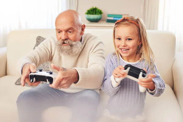 おじいちゃん 子供や遊びや家庭でソファの上で楽しいボンディングでコンソールコントローラとエンターテイメントのためのゲーム 一緒にリビングルームでゲーム レジャー または無料の時間を楽しんで幸せな祖父と子供 — ストック写真