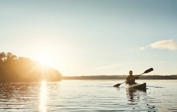 探索户外一个桨的时间 一个年轻人在外面的湖上划船 — 图库照片