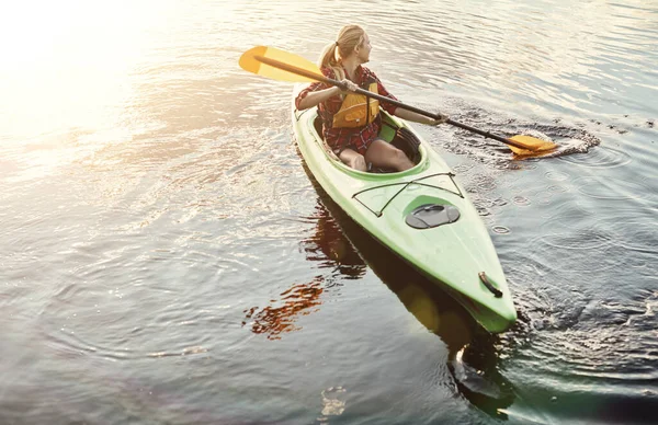 流れに乗ってるだけだ 湖でカヌーに乗るための魅力的な若い女性 — ストック写真