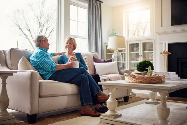 Rule number one in their home. Make yourself comfortable. a happy mature couple relaxing on the sofa and enjoying a coffee break together