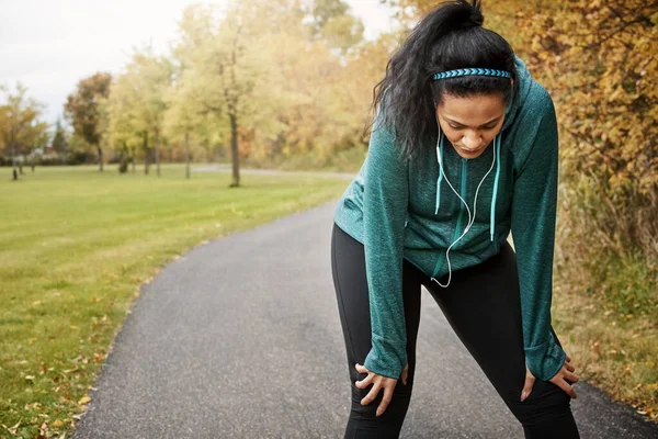 stock image Exercise can be challenging. Do it anyway. an attractive young woman taking a break while out for a run in nature