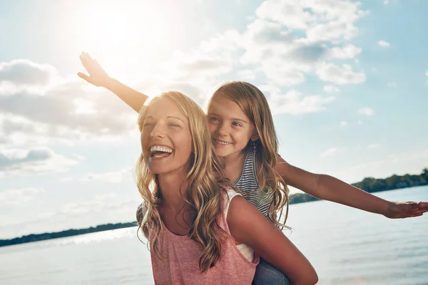 姑娘们玩得很开心一个年轻的女人和她的女儿在海滩度过一段美好的时光 — 图库照片