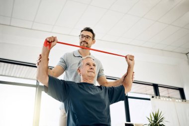 Esneklik ve dayanıklılığı geliştiriyorum. Dost canlısı bir fizyoterapist, olgun hastasının rehabilitasyon merkezinde esnemesine yardım ediyor.