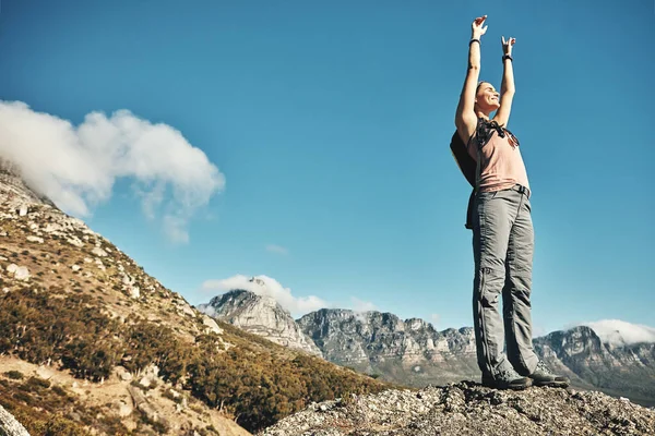 ハイキングは自由を発見する一つの方法です 山の中をハイキング中に祝う若い女性が — ストック写真