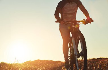 Gününe biraz macera ekle. Tanımlanamayan bir dağ bisikletçisi güneşli bir günde yolda.