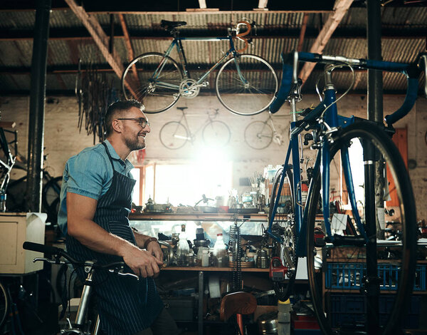 Hes got great plans for your bicycle. a mature man working in a bicycle repair shop