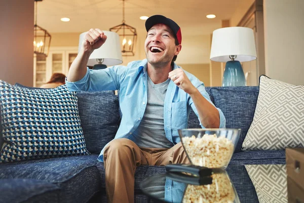 stock image The true fan never misses a game. a happy man celebrating while watching a sports match on tv