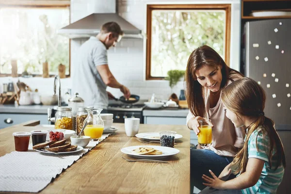 来些果汁怎么样 一家人在家里一起吃早餐 — 图库照片