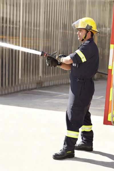Man Brandman Sprayvatten Och Räddningspersonal Med Hjälm Uniform Och Modig — Stockfoto