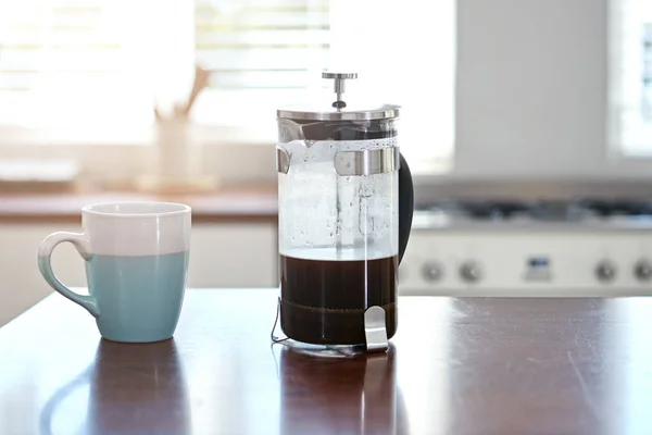 Start your morning right. a mug and french press on a kitchen counter