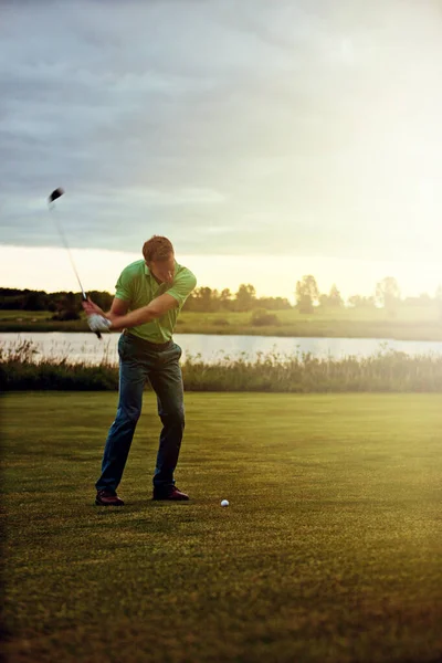 全部形になっている ゴルフ場でスイングの練習をしている男が — ストック写真