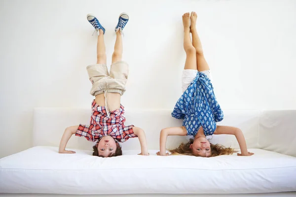 Playful Young Brother Sister Doing Handstands Together Sofa — Stock Photo, Image
