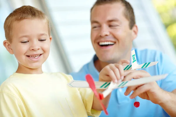 このように お父さん 家で息子と一緒に模型飛行機で遊んでる若い父親 — ストック写真