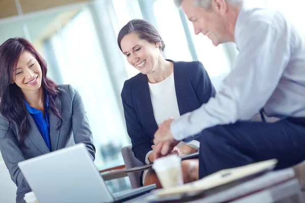 Discutindo Suas Projeções Três Empresários Sentados Juntos Trabalhando Equipe — Fotografia de Stock