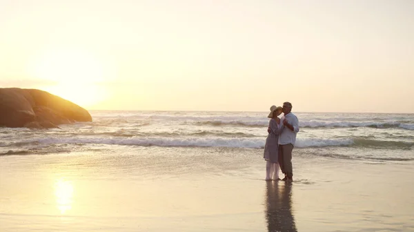 在海浪中跳舞 夕阳西下时一对深情的老夫妇在海滩共舞的全景 — 图库照片