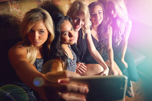 Good vibes, good friends, good times. a group of young women taking a selfie together in a nightclub