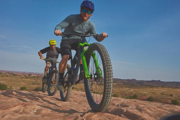 stock image Its all about the ability to endure. Full length shot of two athletic men mountain biking through the wilderness