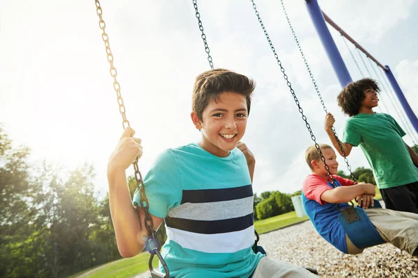 ３人の親友がつるんでる 友達と公園でスイングで遊んでいる若い男の子の肖像画 — ストック写真