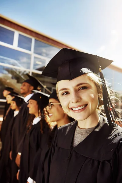 彼女は明るい未来に向かった 卒業の日の笑顔の大学生の肖像を背景にクラスメートと — ストック写真