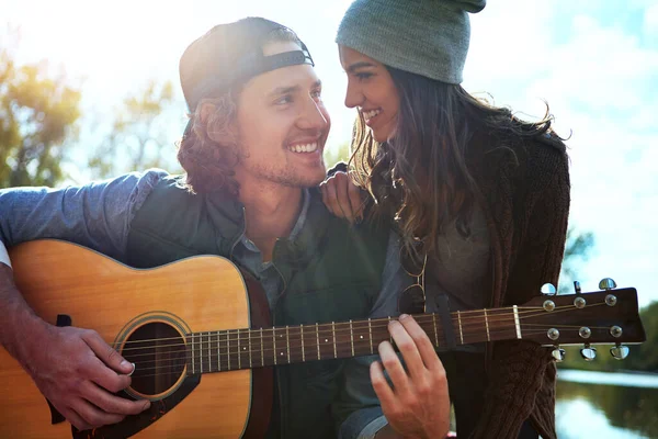 Sana söylemek için çok uzun zamandır bekliyordum. Genç bir adam kız arkadaşına gitarıyla şarkı çalıyor.