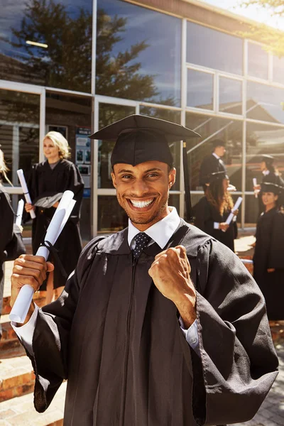 我又活过来了一个微笑的大学生在毕业典礼上在外面拿着文凭的画像 — 图库照片