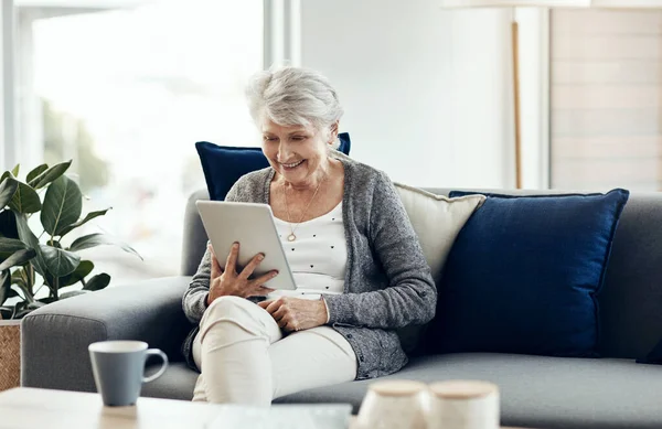 stock image Im just so entertained. a senior woman using a digital tablet while relaxing at home