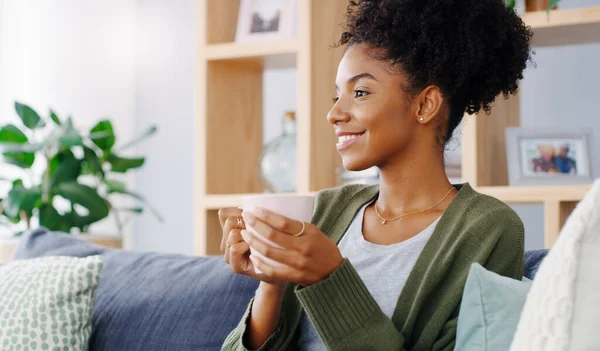 stock image Life is so much better when youre relaxing. an attractive young woman holding a coffee mug while sitting on the sofa in her living room