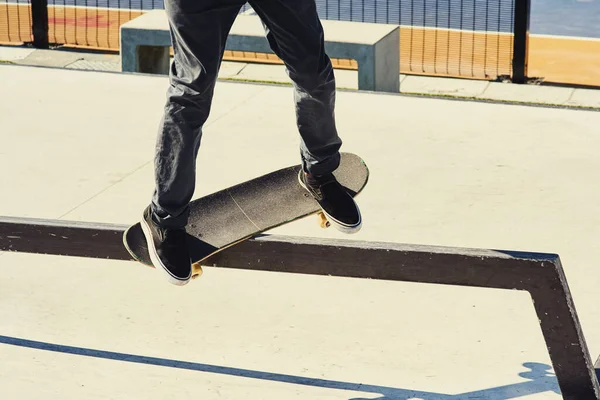 上部へのバンピングと研削 スケートボードを屋外に置いて鉄のレールの上でトリックをしている — ストック写真