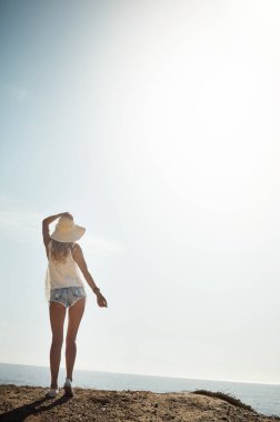Güneşin altında eğlence mevsimi. Çekici bir genç kadının sahildeki gününün tadını çıkarırken çekilmiş dikiz görüntüsü.
