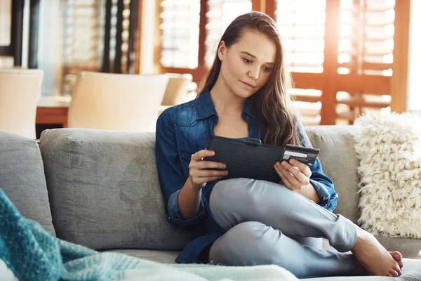 Stock image Banking online. an attractive young woman using her tablet to shop online while relaxing on the sofa at home