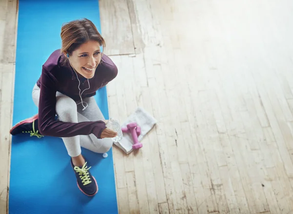 stock image My fuel for a better workout. High angle shot of an attractive young woman drinking water while working out at home