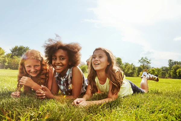 みんなが親友になってよかった 外の草の上に3人の少女が — ストック写真