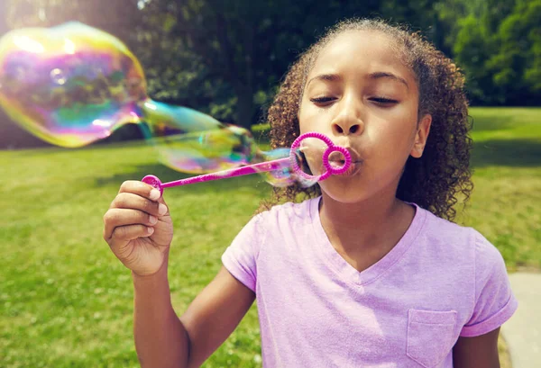 楽しいことは泡を吹いている 屋外で泡を吹いている少女 — ストック写真