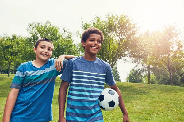 stock image Whos up for some soccer. two young boys out for a game of soccer in the park