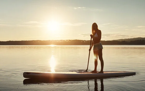 板子上的美女一位年轻貌美的女子在湖上划船 — 图库照片