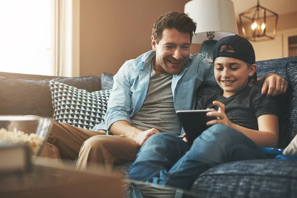 stock image Screen time is supervised in this house. a father and his son using a digital tablet together on the sofa at home