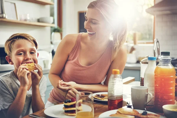 煎饼是他的最爱 当他吃早饭时 一个女人和她的儿子坐在一起 — 图库照片