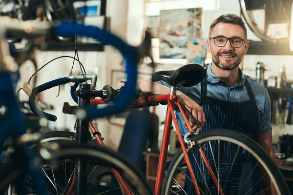 合适的人处理你的自行车整修 一个成熟男子在自行车修理店工作的画像 — 图库照片