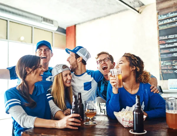 stock image Sports fans go hard or go home. a group of friends having beers while watching a sports game at a bar