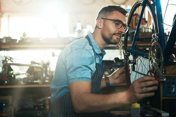 Hands on expertise in the maintenance of your bike. a mature man working in a bicycle repair shop