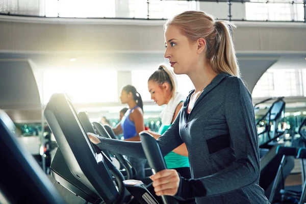 stock image Taking the right steps to a healthy life. a young woman working out with a machine at a gym