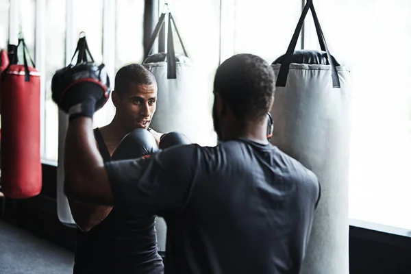 強く訓練し 簡単に戦う コーチと一緒に動きを練習する男性ボクサーが — ストック写真