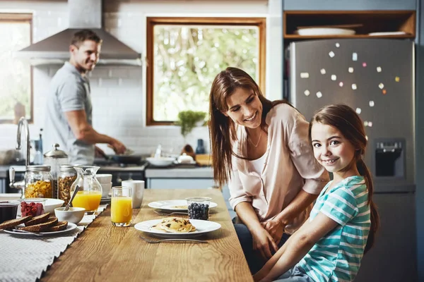 妈妈做的煎饼是最好吃的 一个小女孩在家里和父母一起吃早餐的画像 — 图库照片
