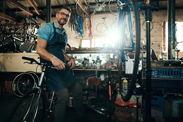 去找男人来满足你所有的自行车需求一个成熟男子在自行车修理店工作的画像 — 图库照片