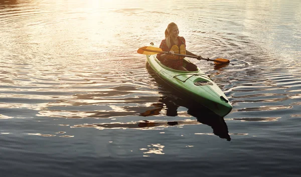 水路を探索し 同時に収まるようになります 湖でカヌーに乗るための魅力的な若い女性 — ストック写真