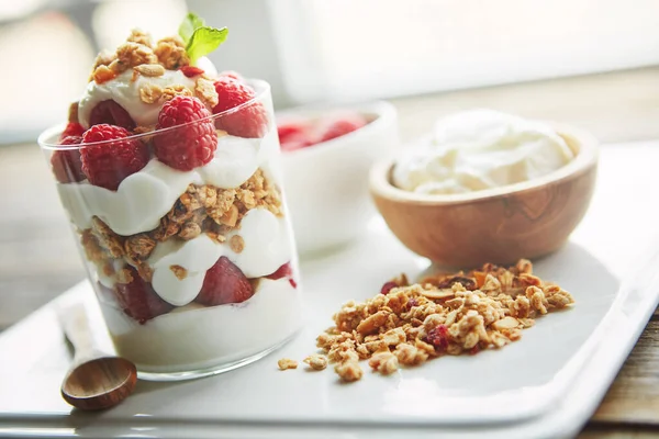 Why not start your day the delicious way. of granola, yoghurt and berries in a glass and on a plate